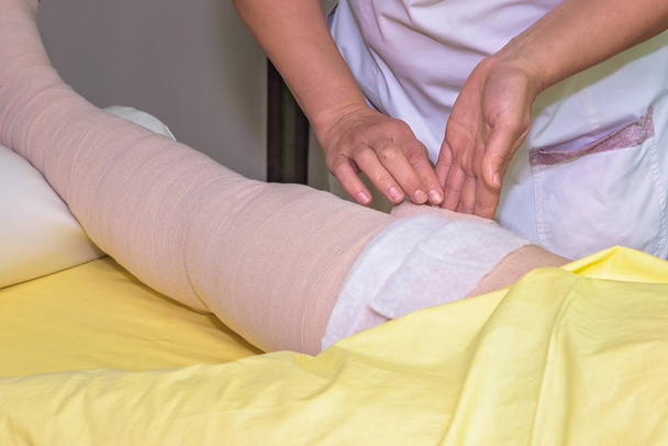 stock-photo-lymphedema-management-wrapping-leg-using-multilayer-bandages-control-lymphedema-part